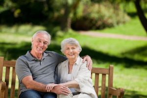 Older couple sitting on park bench